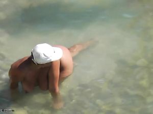 Обнаженная сучка нежится в реке и не догадывается, что за ней следят