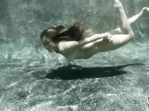 Молодая голая девица купается под водой