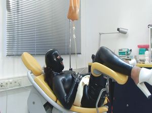Фетишистка в латексе мастурбирует в гинекологическом кресле