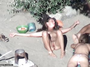 Голая телка на пляже загорает расставив ноги