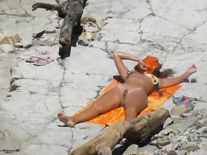 Загорелая сука валяется на скалистом берегу